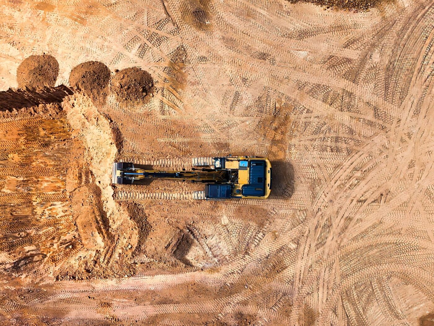 A tracked machine shaping a graded dirt pad
